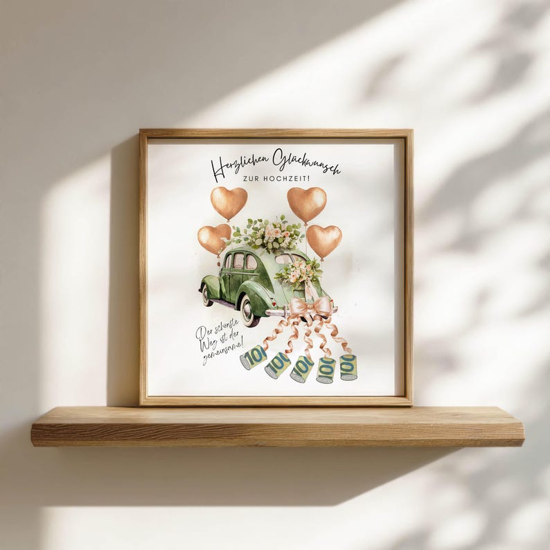 May include: A framed watercolor print featuring a green vintage car decorated with flowers and ribbons, with heart-shaped balloons. The print includes German text, with money cascading from the car, and is displayed on a wooden shelf.