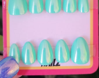 Puede incluir: Un conjunto de diez uñas postizas ovaladas de color verde azulado con un acabado brillante. Las uñas se muestran en una tarjeta rosa y amarilla con el texto "A+Z Nails".
