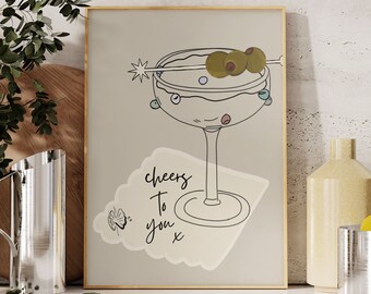 May include: A printable art print featuring a line drawing of a martini glass with olives and the text "Cheers to you x". The print is on a light green background with a white paper texture.