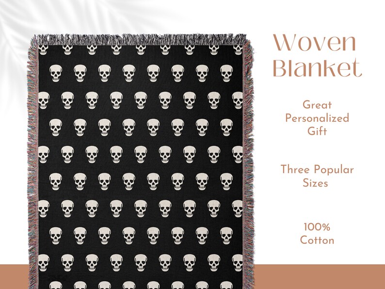 May include: Black and white woven throw blanket with a skull pattern. The blanket has fringe on all sides. The text "Woven Blanket" is written in brown text above the blanket. The text "Great Personalized Gift" is written in brown text below the blanket. The text "Three Popular Sizes" is written in brown text below the blanket. The text "100% Cotton" is written in brown text below the blanket.