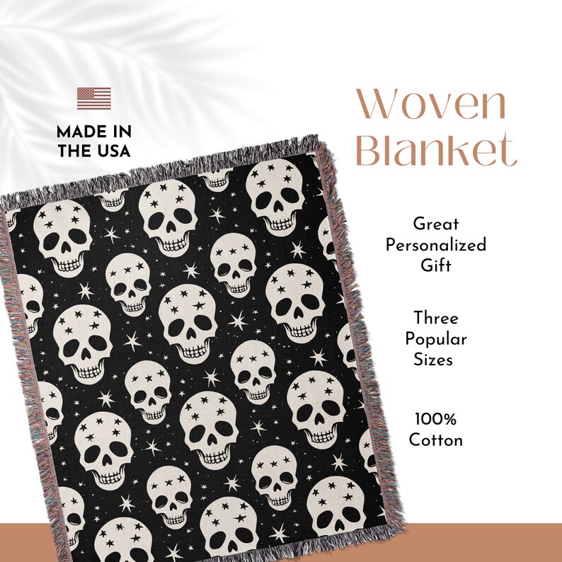 May include: Black and white woven throw blanket with a skull and star pattern. The blanket has fringe on all sides. The text "Made in the USA" is in the top left corner. The text "Woven Blanket" is in the top right corner. The text "Great Personalized Gift" is in the middle right corner. The text "Three Popular Sizes" is below the text "Great Personalized Gift". The text "100% Cotton" is in the bottom right corner.