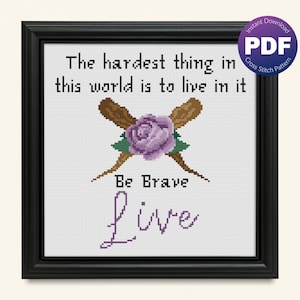 May include: Cross stitch pattern featuring a purple rose with two crossed wooden sticks, with the text "The hardest thing in this world is to live in it" and "Be Brave Live" in purple.