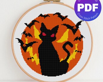 May include: Cross stitch pattern featuring a black cat with red eyes sitting in front of a full orange moon with bats flying around it.