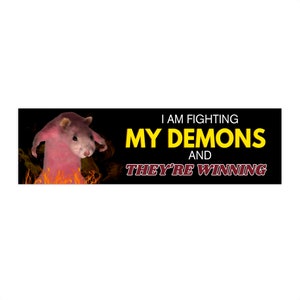 Könnte beinhalten: Humorvolle Grafik mit einem rosa hamsterartigen Wesen in Flammen. Der Text lautet "I AM FIGHTING MY DEMONS AND THEY'RE WINNING" in gelben und roten Schriftarten vor schwarzem Hintergrund. Das Bild ist ein Design im Meme-Stil.