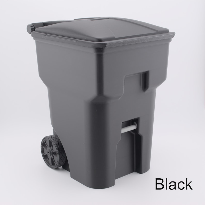 K&ouml;nnte beinhalten: Eine schwarze M&uuml;lltonne mit R&auml;dern und einem Klappdeckel. Die Tonne hat zwei R&auml;der und einen Griff f&uuml;r den einfachen Transport. Das Wort "Black" ist unten rechts aufgedruckt.