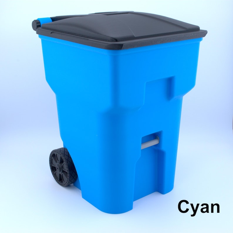 K&ouml;nnte beinhalten: Ein cyanfarbener M&uuml;lleimer mit schwarzem Deckel und R&auml;dern. Der rollbare M&uuml;lleimer hat eine rechteckige Form mit einem Griff und ist f&uuml;r den Au&szlig;enbereich konzipiert. Das Wort "Cyan" ist unten rechts aufgedruckt.