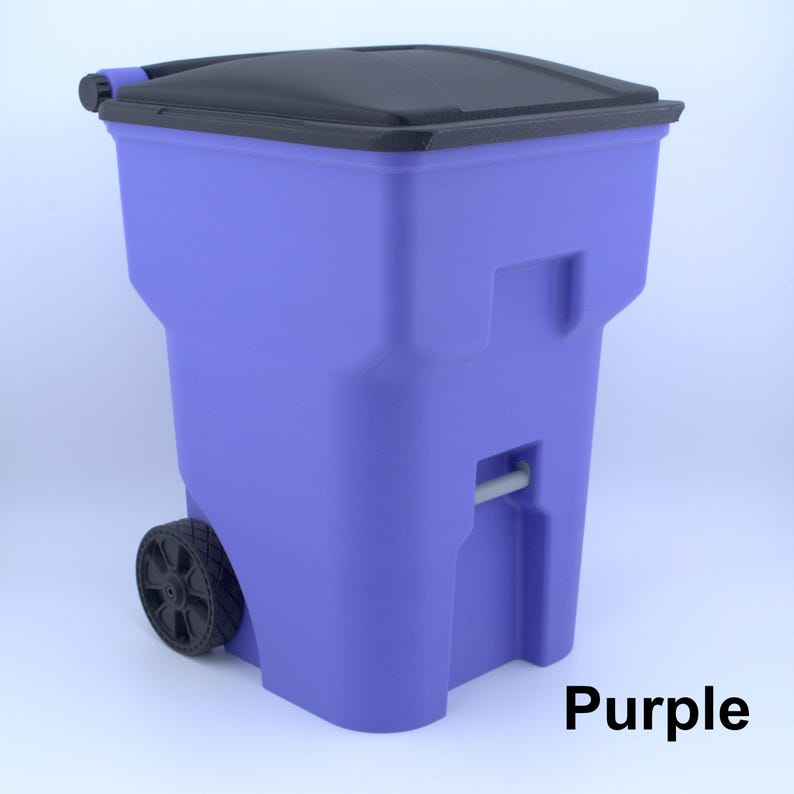 K&ouml;nnte beinhalten: Eine lila M&uuml;lltonne mit schwarzem Deckel. Die Tonne hat eine rechteckige Form mit einem Griff und einem Rad an der Seite. Das Wort "Purple" ist unten rechts aufgedruckt.