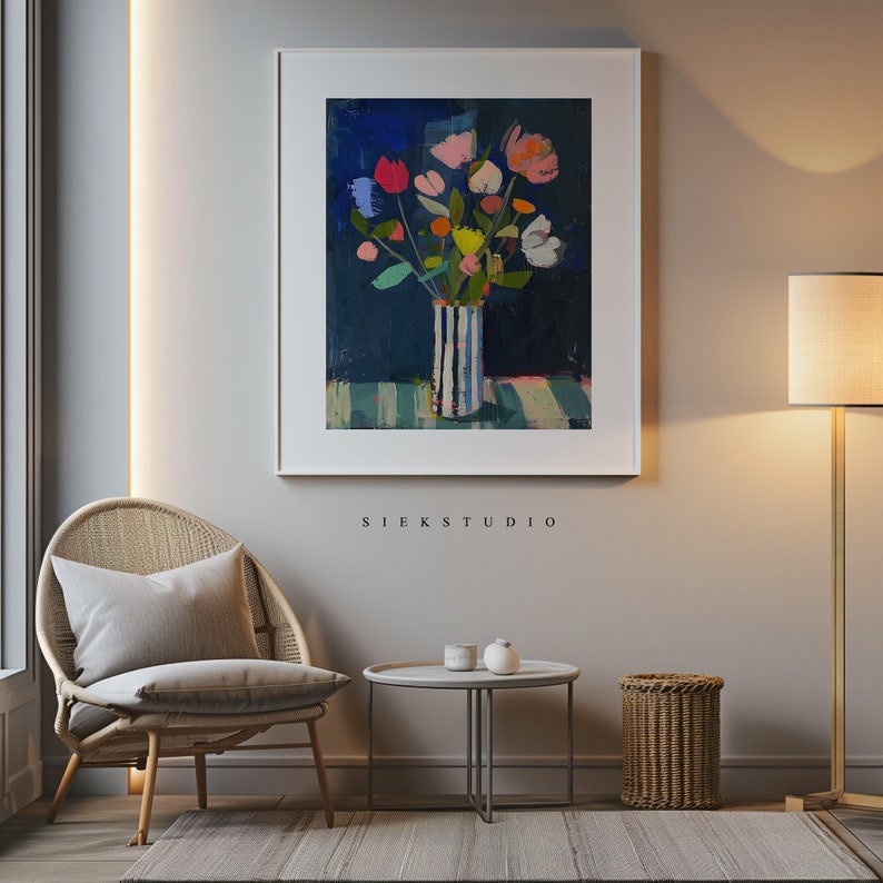 May include: A painting of a bouquet of colorful flowers in a striped vase on a blue and green striped background. The painting is framed in a white frame and hangs on a light gray wall.