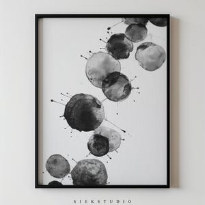 May include: Framed monochrome abstract art print. The artwork displays a series of overlapping, ink-like circles with splatters, creating a dynamic design. The text "SIEK STUDIO" is printed at the bottom of the print.