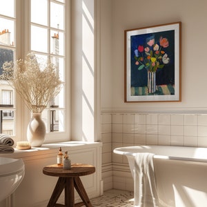 May include: A white bathtub with a white towel hanging over the side, a wooden stool with two bottles and a jar on top, and a framed print of a colorful floral arrangement in a striped vase against a blue background. The print is titled "SIEKSTUDIO".