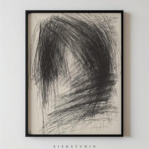 May include: Abstract black and white artwork in a black frame. The artwork features a dense, scribbled design with a central, curved shape. The text "SIEK STUDIO" is printed in a minimalist font at the bottom of the frame.
