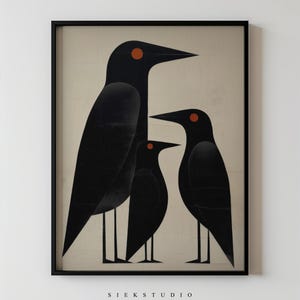 Peut inclure: Impression d'art encadrée représentant trois corbeaux noirs stylisés aux yeux orange sur fond crème. L'œuvre minimaliste porte le texte "SIEK STUDIO" en bas, dans un cadre noir simple.