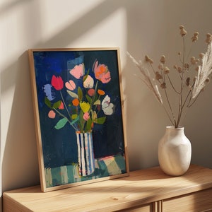 May include: A framed painting of a colorful bouquet of flowers in a blue and white striped vase. The flowers are painted in a loose, abstract style and the background is a deep blue.
