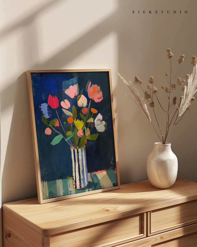 May include: A framed painting of a colorful bouquet of flowers in a blue and white striped vase. The flowers are painted in a loose, abstract style and the background is a deep blue.