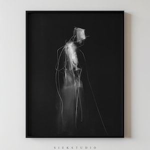Puede incluir: Impresión artística enmarcada en negro con una figura abstracta minimalista en blanco sobre un fondo negro. La obra de arte tiene una calidad de boceto con líneas y sombreado visibles. El texto "SIEK STUDIO" está impreso en la parte inferior.