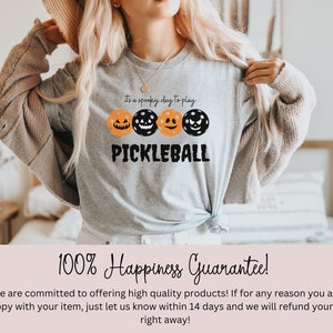 May include: A gray t-shirt with a black and orange pumpkin design and the text "It's a spooky day to play Pickleball".