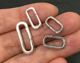 May include: Four silver-toned metal jump rings. Two are plain and two have a rope-like texture.