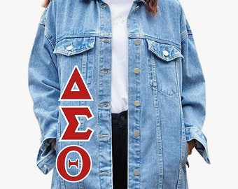 May include: A light blue denim jacket with a red, white, and white Greek letter design on the left side. The letters are Delta, Sigma, and Theta.