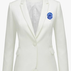 May include: A white blazer with a single button closure and a blue embroidered patch on the left lapel. The patch features a shield with the letters "ZOB" and stars.