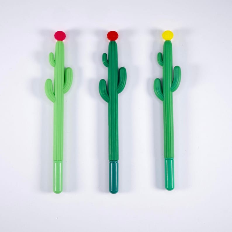 May include: Three green cactus-shaped pens with different colored tops. The pens have red, yellow, and blue tops.