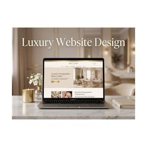 May include: A laptop displays a website design with the text "Luxury Website Design." The website showcases a beauty salon with images and text. A lit candle, flowers, and a book are on the marble surface.