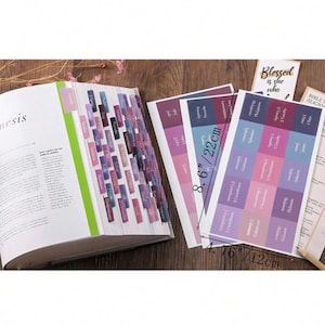 May include: Bible tabs and stickers with a variety of colors, including purple, pink, and blue. The tabs are attached to the pages of a book, and the stickers are shown separately. The stickers measure 4.76 inches by 8.6 inches.