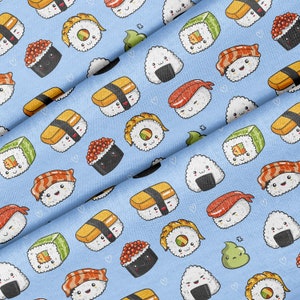 Könnte beinhalten: Ein blauer Stoff mit einem sich wiederholenden Muster aus verschiedenen Sushi- und Onigiri-Sorten. Die Sushi und Onigiri sind alle Comicfiguren mit lächelnden Gesichtern.