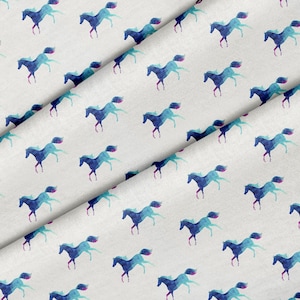 Peut inclure: Tissu blanc avec un motif répété de chevaux aquarelle bleus et violets courant vers la droite.