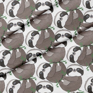 May include: A white fabric with a repeating pattern of brown sloths hanging upside down. The sloths have black eyes and a light brown face.