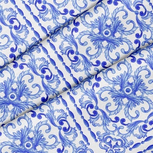 May include: Blue and white fabric with a repeating pattern of stylized floral designs. The fabric is folded in half, showing the pattern on both sides.