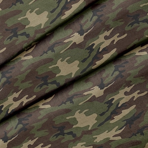 Puede incluir: Tela de camuflaje con un patrón verde, marrón y negro. La tela está doblada por la mitad, mostrando el patrón en ambos lados.