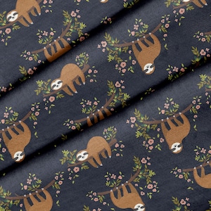 May include: A dark blue fabric with a repeating pattern of brown sloths hanging from branches with pink flowers.