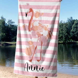 May include: Pink and white striped beach towel with a pink flamingo illustration and the name "Annie" printed on the bottom.