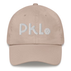 May include: A beige baseball cap with white embroidered text that reads "DKL" and a small white embroidered golf ball.
