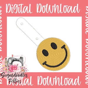 May include: A digital download of an embroidery design featuring a yellow smiley face with a black outline. The design includes a loop for attaching to a keychain or other item.