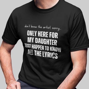 May include: A black short-sleeved t-shirt featuring white text that reads: don't know the artist, sorry... ONLY HERE FOR MY DAUGHTER JUST HAPPEN TO KNOW ALL THE LYRICS. The shirt has a crew neckline and a standard fit, displaying the printed message clearly.