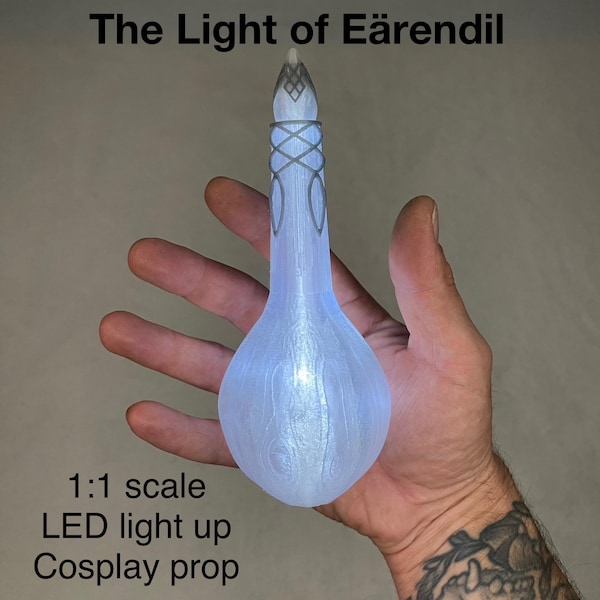 May include: A glowing, light blue cosplay prop shaped like a bulb with intricate silver detailing. The text "The Light of Äärendil" is at the top, and "1:1 scale LED light up Cosplay prop" is at the bottom.