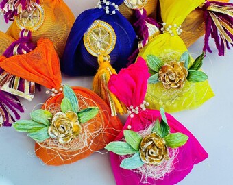 May include: Assortment of colorful fabric pouches with gold accents and decorative embellishments. The pouches are filled with dried herbs and flowers.