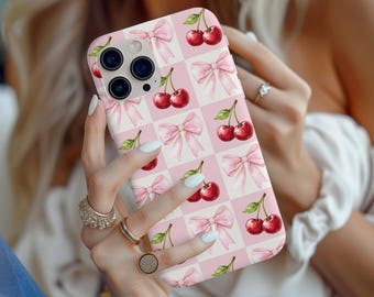 May include: A pink and white phone case with a pattern of cherries and pink bows.