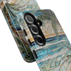 May include: A mosaic-style phone case featuring a beach scene with palm trees, ocean waves, and a sunset. The case has a multi-lens camera cutout and a textured, artistic design. The color palette includes blues, greens, and yellows.