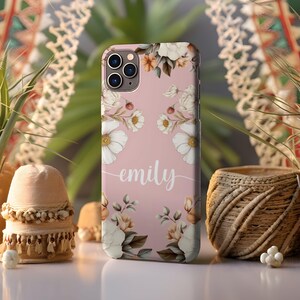 May include: A pink phone case with a floral design and the name "emily" written in white script.