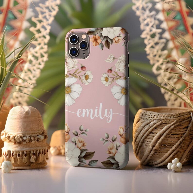 May include: A pink phone case with a floral design and the name "emily" written in white script.