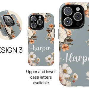 May include: A gray phone case with a floral design and the name "Harper" printed on it. The flowers are in shades of orange, brown, and white.