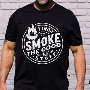 May include: Black t-shirt with a white circle graphic that says "I only smoke the good stuff" with a grill and flames inside the circle.