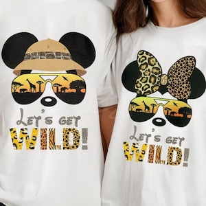 May include: White t-shirts with a Mickey Mouse and Minnie Mouse design. The shirts feature a safari-themed design with sunglasses, a hat, and a bow. The text on the shirts reads "Let's get wild!"