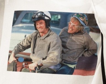 May include: White sweatshirt with a graphic print of two men riding a motorcycle. The men are wearing helmets and sunglasses. The sweatshirt has black and white stripes on the sleeves.