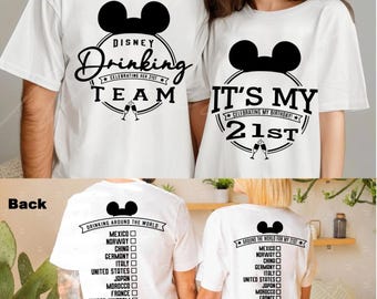 May include: Two white t-shirts with black Mickey Mouse ears and text. The first shirt says "Disney Drinking Team Celebrating Her 21st". The second shirt says "It's My 21st Celebrating My Birthday". The back of the shirts have a list of countries with checkboxes next to them.