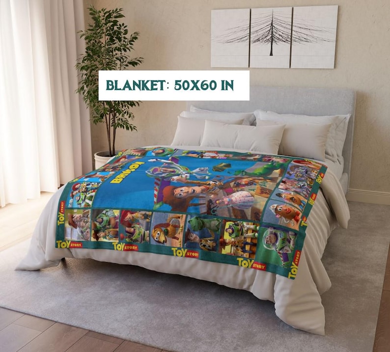 May include: A blue blanket featuring characters from the animated film "Toy Story." The blanket measures 50 x 60 inches and has a green border with the words "Toy Story" printed on it. The blanket is spread across a bed with white bedding.