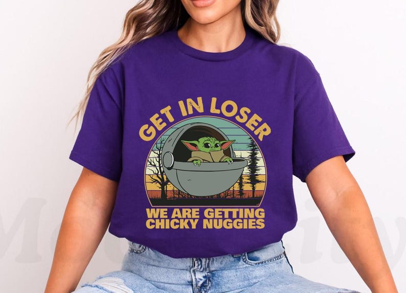 May include: Purple t-shirt featuring a graphic of a green alien character in a pod with the text "GET IN LOSER WE ARE GETTING CHICKY NUGGIES" in yellow and white. The design has a retro sunset and forest background.