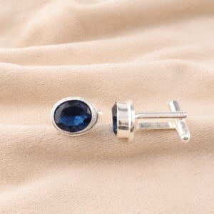 Op de afbeelding: Een paar zilveren manchetknopen met ovale blauwe edelstenen.